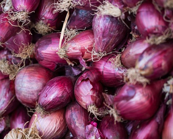 Fresh raw onions on wooden background. Top view.
